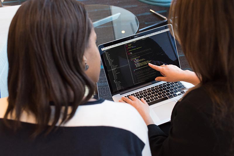 two people using a laptop