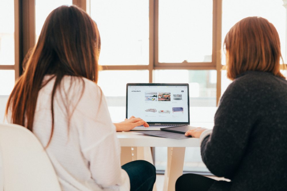 two people using a laptop